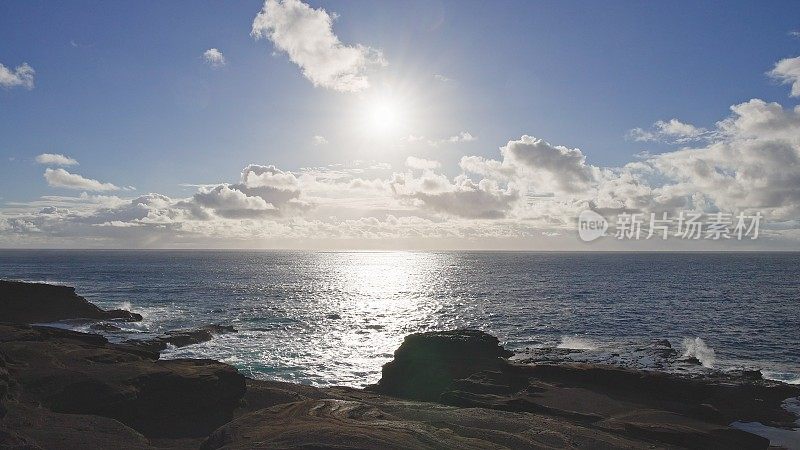 瓦胡岛的日出。白云飘过蓝天。太平洋的蓝色海浪打败了瓦胡岛火山悬崖。蓝绿色的水的颜色。晴朗的一天。DCI 4 k